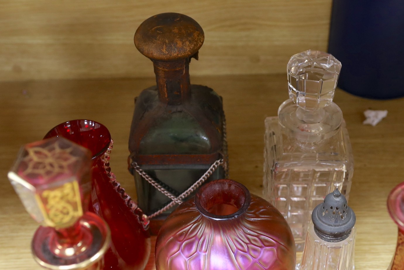 A pair of Bohemian gilded ruby glass decanters and stoppers, a Bohemian ‘millefiori paperweight’ stopper and associated decanter and mixed glass